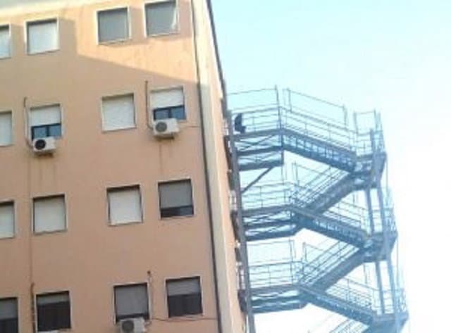 Sale sull'ultima rampa della scala d'emergenza e tenta di gettarsi